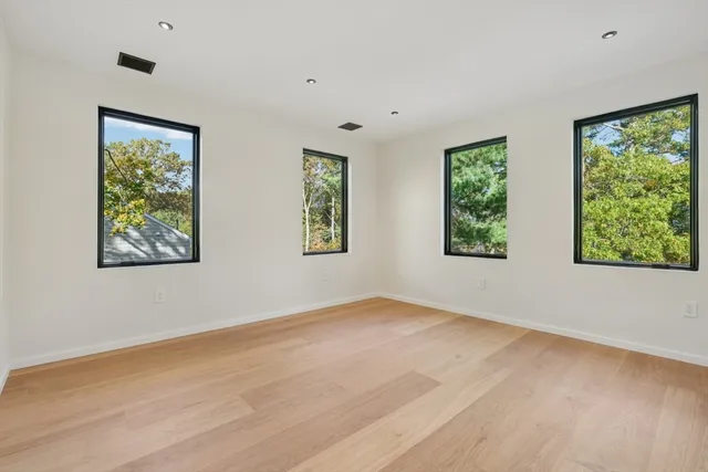 a view of an empty room with a window and a ceiling fan