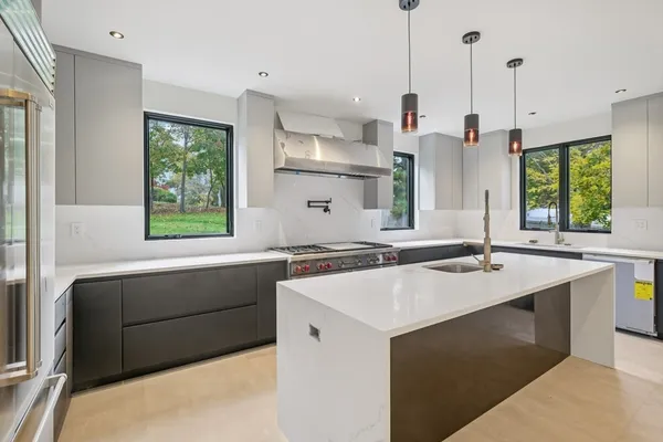 a kitchen with a stove a sink and a wooden floor