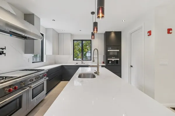 a kitchen with granite countertop a sink appliances and cabinets