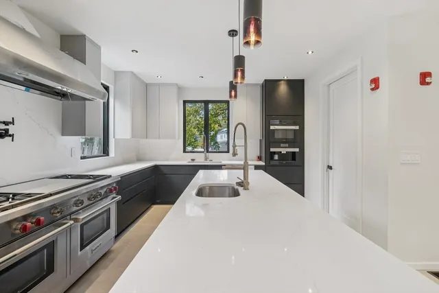 a kitchen with granite countertop a sink appliances and cabinets
