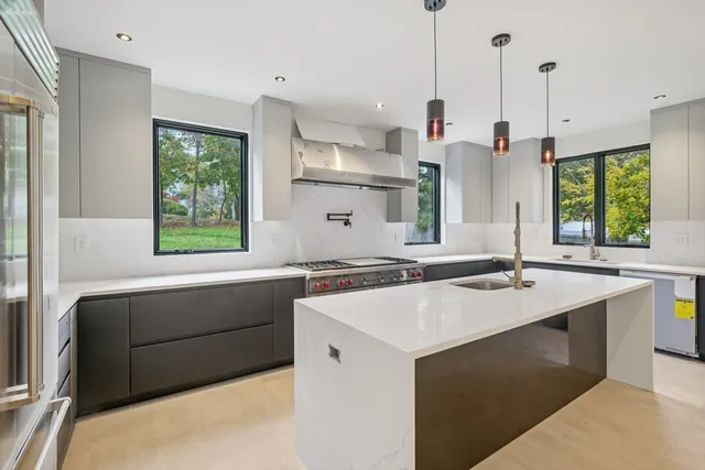 a kitchen with a stove a sink and a wooden floor