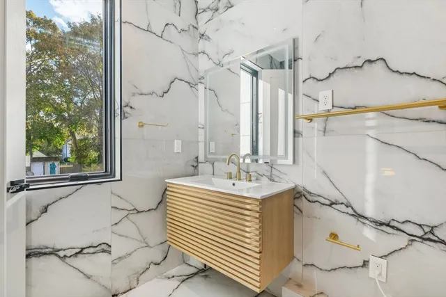 a bathroom with a sink and mirror with bathtub