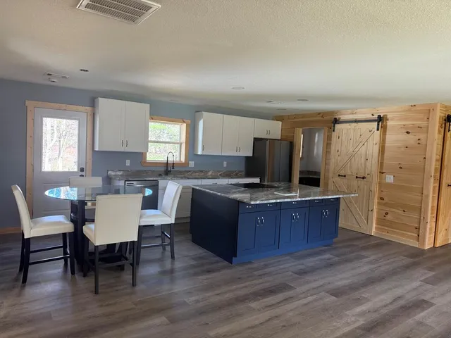 a kitchen with granite countertop a sink stove and cabinets