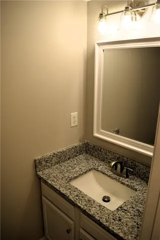 a bathroom with a granite countertop sink and vanity