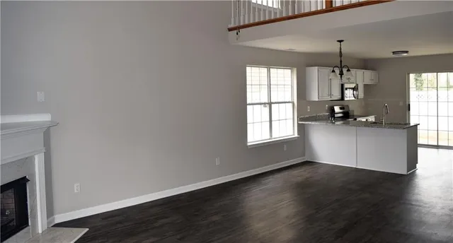 a kitchen with granite countertop a stove and a wooden floor