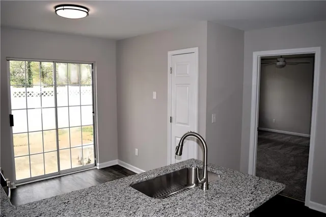 a view of a kitchen with granite countertop a sink and a window