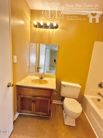 a bathroom with a granite countertop toilet sink and mirror