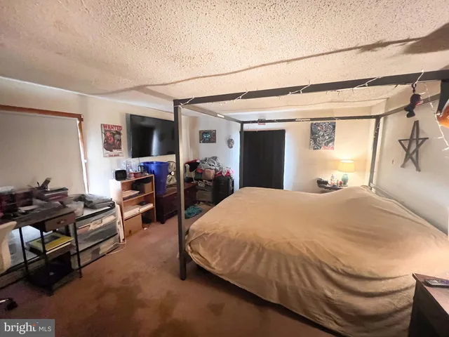 a spacious bedroom with a bed and a flat screen tv
