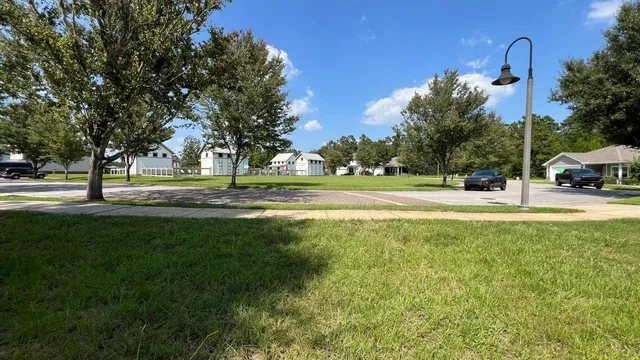 a view of a yard with a house and a large tree