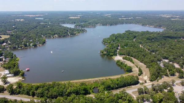 an aerial view of lake and residential houses with outdoor space