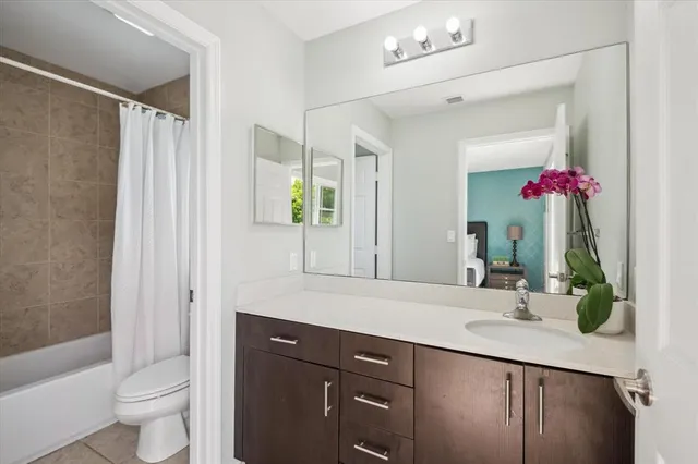 a bathroom with a granite countertop sink a toilet and shower