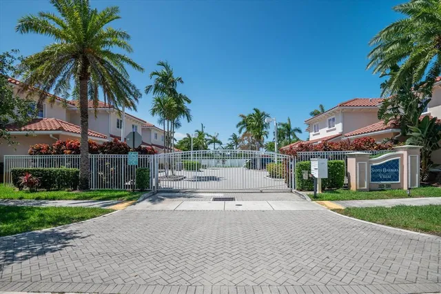a view of a white house with a yard and potted plants