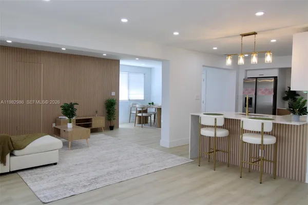 a living room with furniture and a dining table with wooden floor