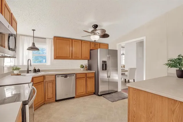 a kitchen with stainless steel appliances a stove a sink and a refrigerator