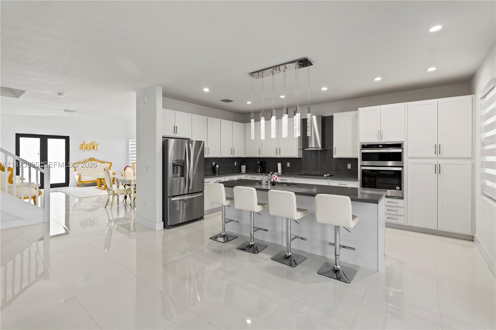 14841 Southwest 39th Terrace Miami, FL 33185 - Photo 17 of 57 a kitchen with stainless steel appliances kitchen island granite countertop a refrigerator and white cabinets