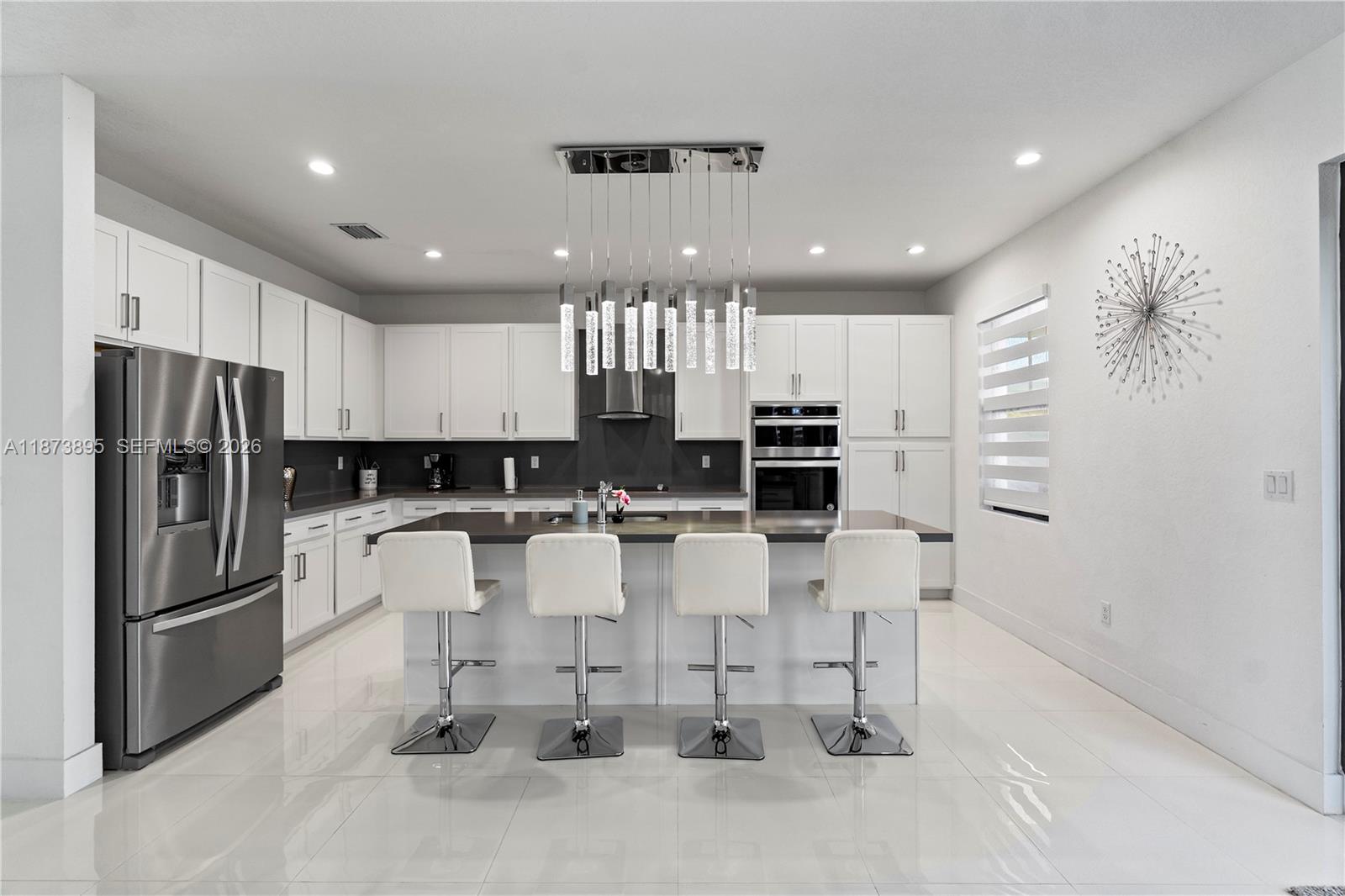 14841 Southwest 39th Terrace Miami, FL 33185 - Photo 18 of 57 a kitchen with stainless steel appliances kitchen island granite countertop a refrigerator and a stove top oven