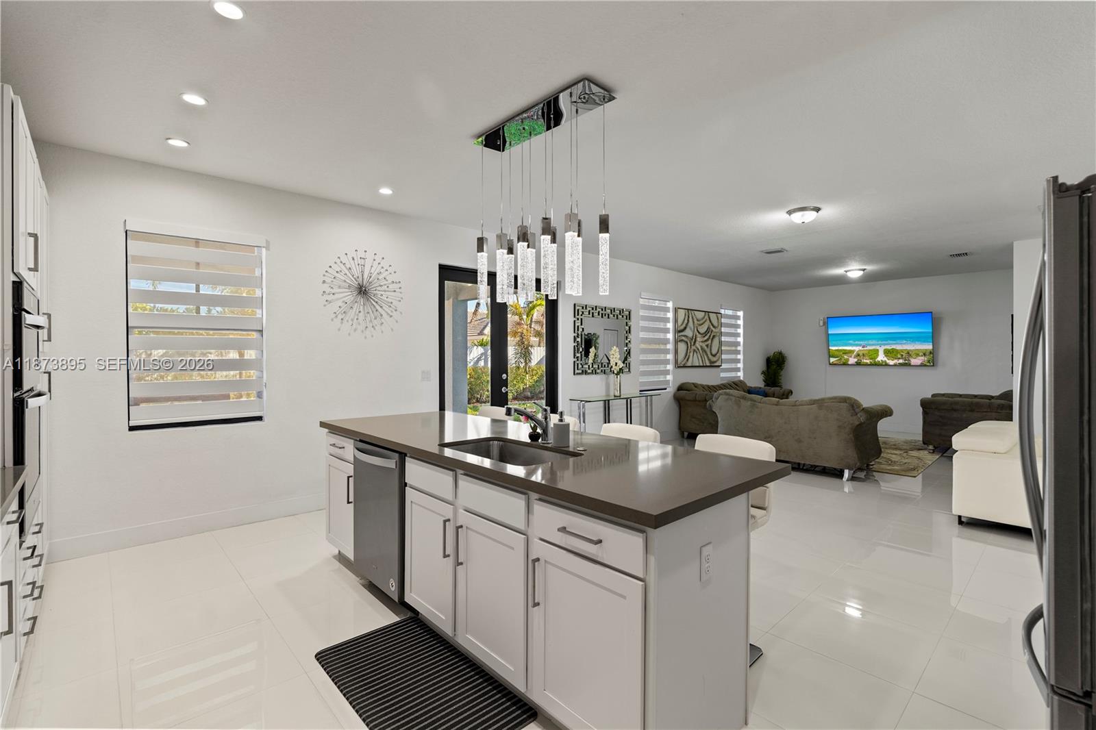 14841 Southwest 39th Terrace Miami, FL 33185 - Photo 20 of 57 a kitchen with kitchen island granite countertop a sink and a refrigerator