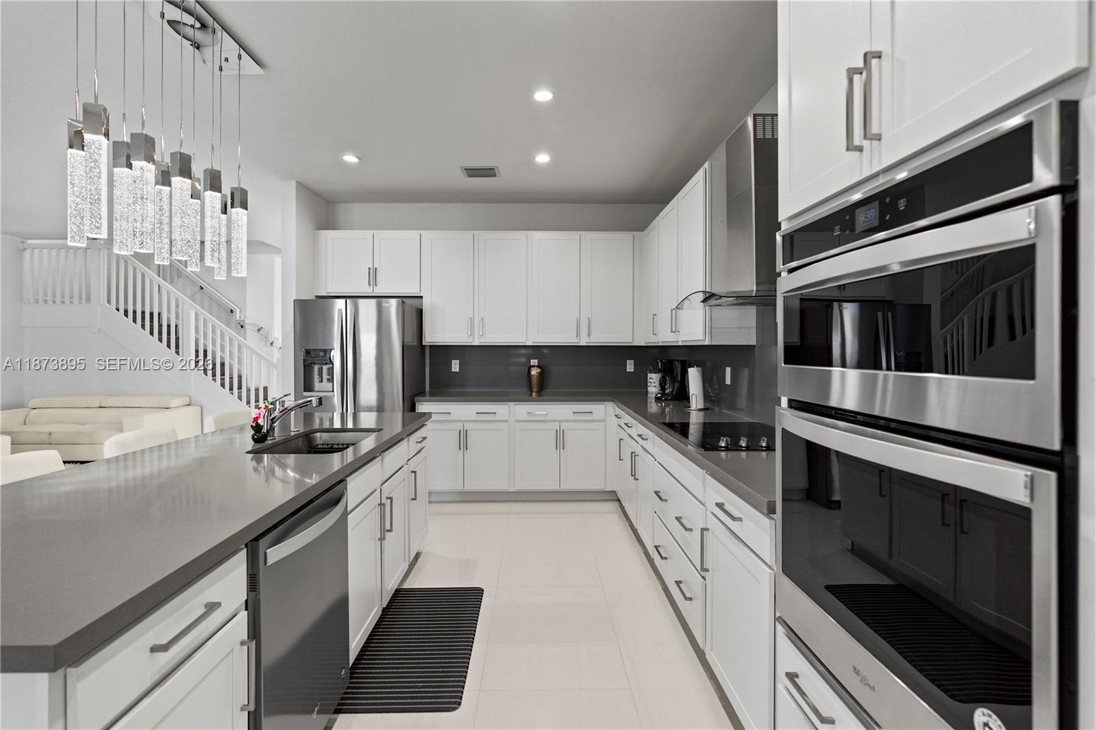 14841 Southwest 39th Terrace Miami, FL 33185 - Photo 21 of 57 a large white kitchen with stainless steel appliances