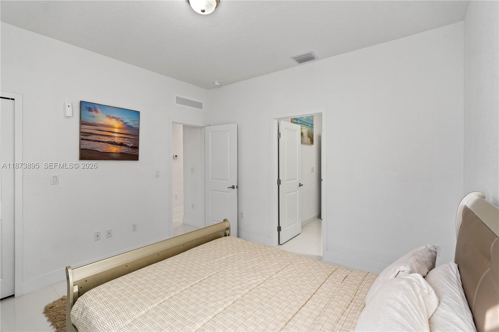 14841 Southwest 39th Terrace Miami, FL 33185 - Photo 41 of 57 a bedroom with a bed and a painting on the wall