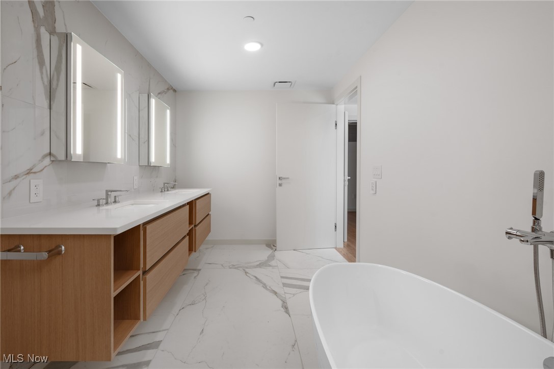 22700 Lake Road, Unit 306 Rocky River, OH 44116 - Photo 17 of 28 Bathroom with light marble finish floors, double vanity, and a freestanding bath