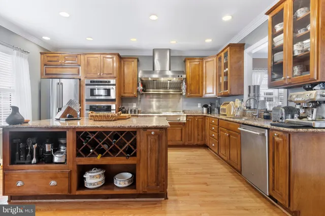 a kitchen with stainless steel appliances granite countertop a sink a stove and cabinets