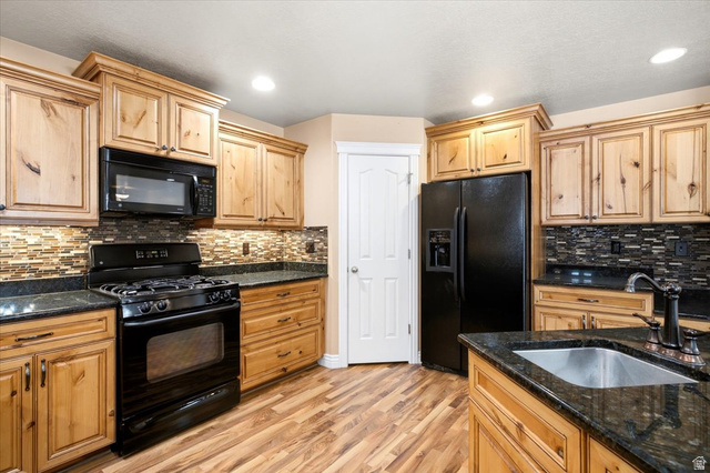 1089 West 2325th Street North Layton, UT 84041 - Photo 12 of 40 Kitchen featuring wood-finish cabinetry, black appliances, dark countertops, and a mosaic tile backsplash
