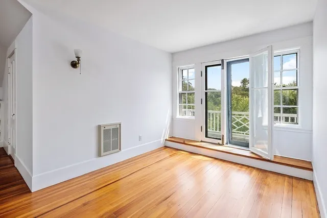 a view of a livingroom with wooden floor and a window