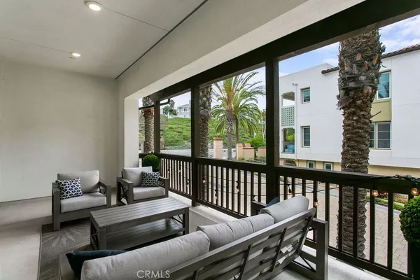a balcony with wooden floor and outdoor seating