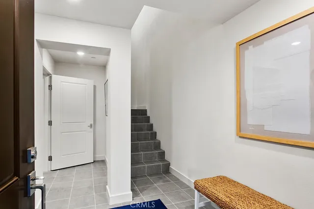a view of a hallway with entryway and wooden floor