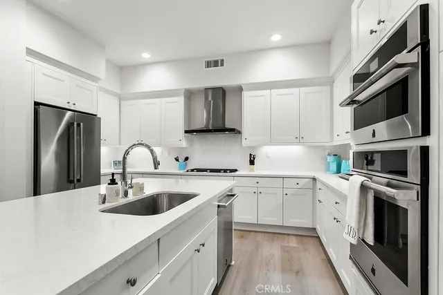 a kitchen with cabinets stainless steel appliances and a sink