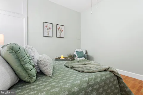 a bedroom with a bed a mirror and potted plants