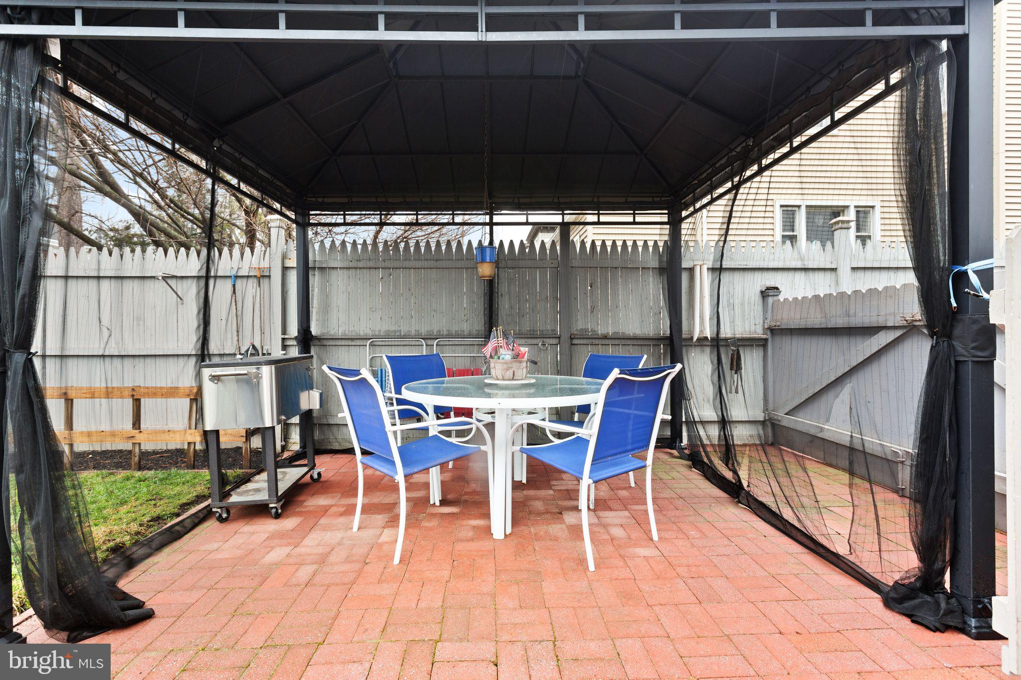 110 Potter Street Haddonfield, NJ 08033 - Photo 30 of 48 a view of a patio with table and chairs under an umbrella with wooden floor
