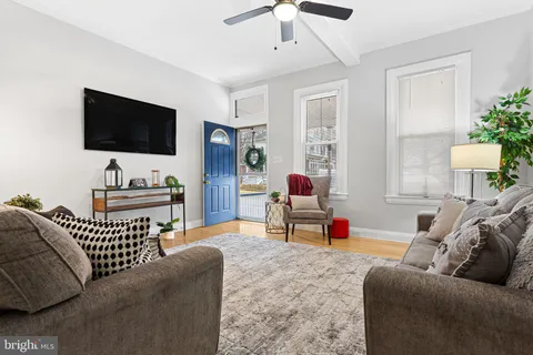 a living room with furniture ceiling fan and a rug