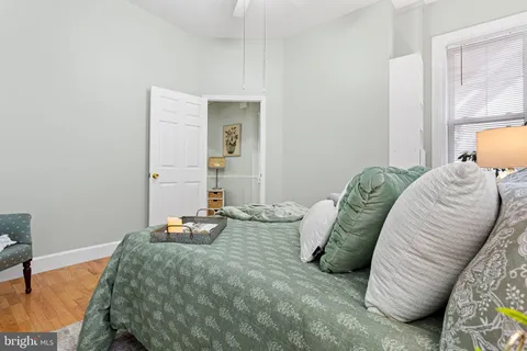 a bedroom with a bed and painting on the wall