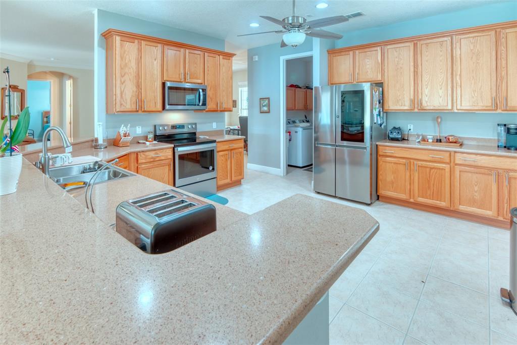 729 Glendora Road Kissimmee, FL 34759 - Photo 12 of 56 a kitchen with stainless steel appliances granite countertop a refrigerator a stove top oven a sink and dishwasher