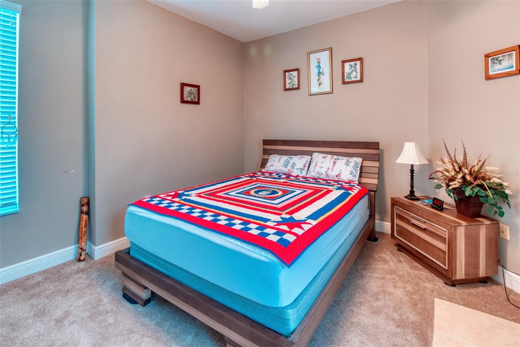 729 Glendora Road Kissimmee, FL 34759 - Photo 40 of 56 a room with a bed and a lamp next to a window