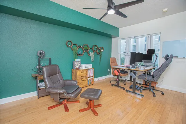 a workspace with furniture and a ceiling fan