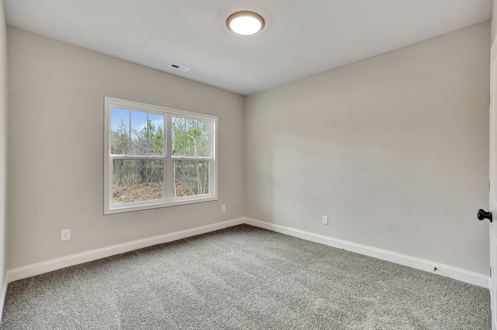 118 Bonaire Point Anderson, SC 29621 - Photo 22 of 23 This bright and airy room features soft carpeting and a large window overlooking lush greenery.