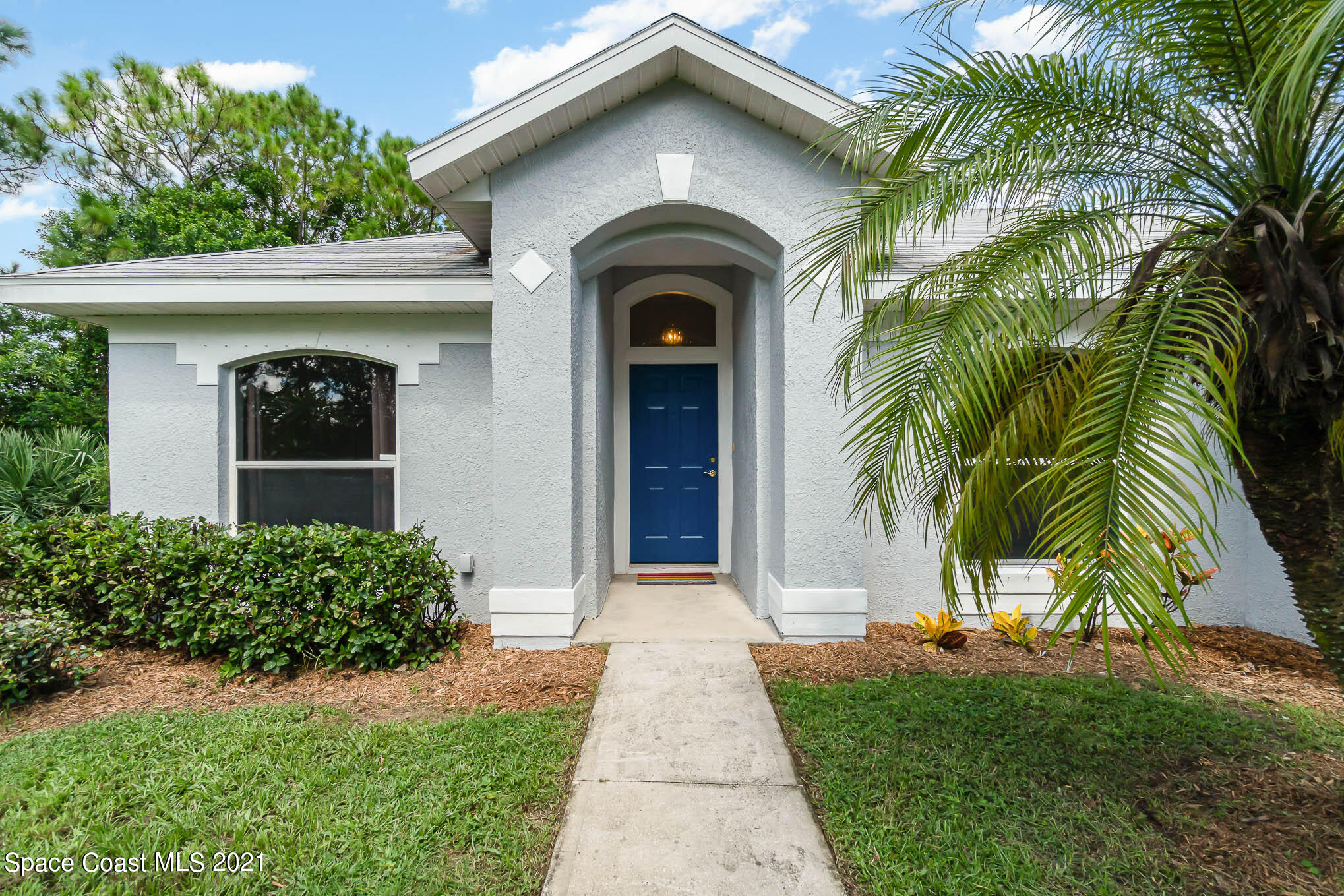 1380 Ran Road Southeast Palm Bay, FL 32909 - Photo 3 of 20 a view of a house with a small yard plants and a palm tree