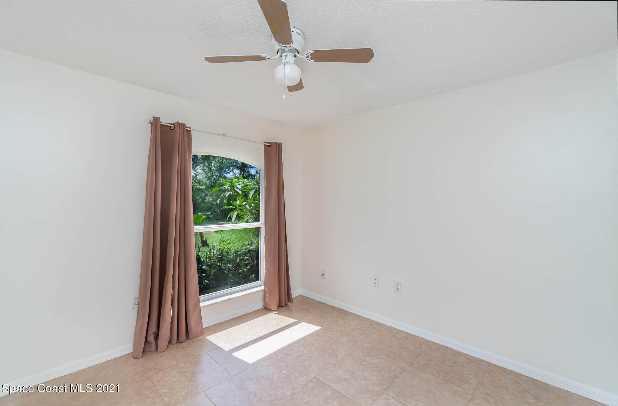 1380 Ran Road Southeast Palm Bay, FL 32909 - Photo 9 of 20 an empty room with a window and a fan
