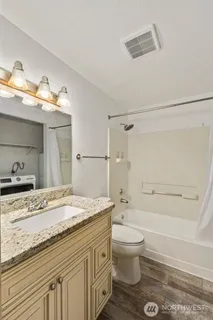 a bathroom with a granite countertop sink toilet and shower