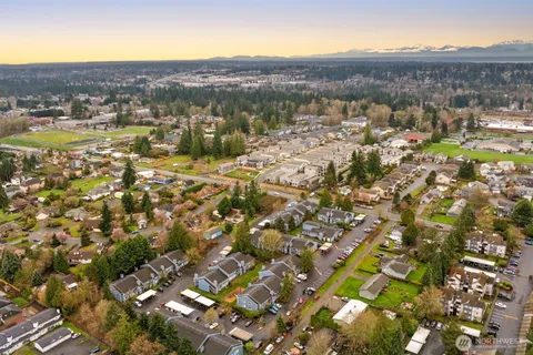 an aerial view of residential houses with outdoor space and trees