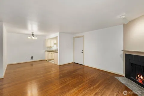a view of empty room with wooden floor and fireplace
