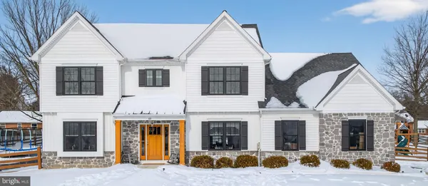 a view of a white house with large windows and a small yard