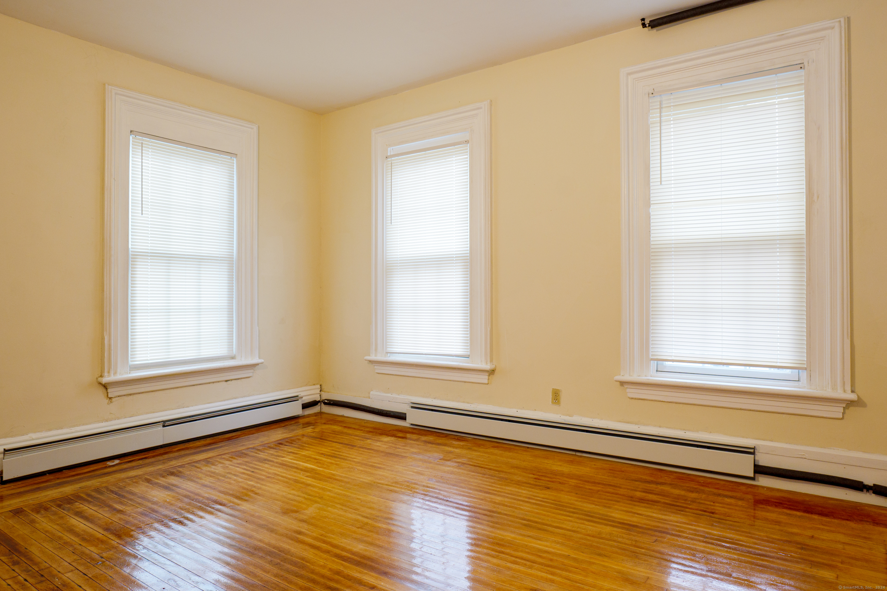30 Main Street Plainfield, CT 06332 - Photo 13 of 16 an empty room with wooden floor and windows