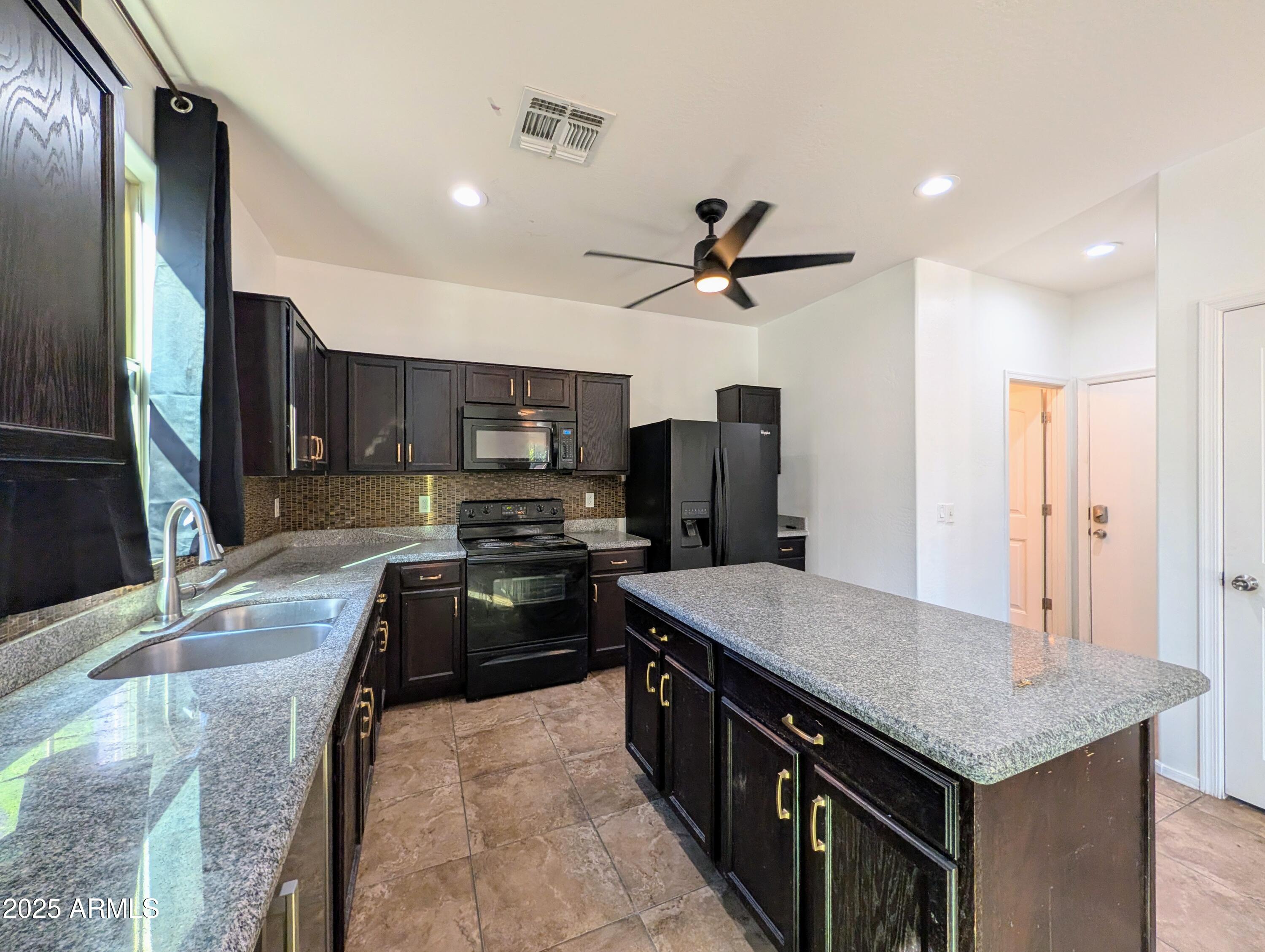 4726 West Fremont Rd. Laveen, AZ 85339 - Photo 13 of 50 a kitchen with stainless steel appliances granite countertop a sink stove and refrigerator