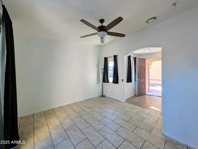 an empty room with ceiling fan and a fan