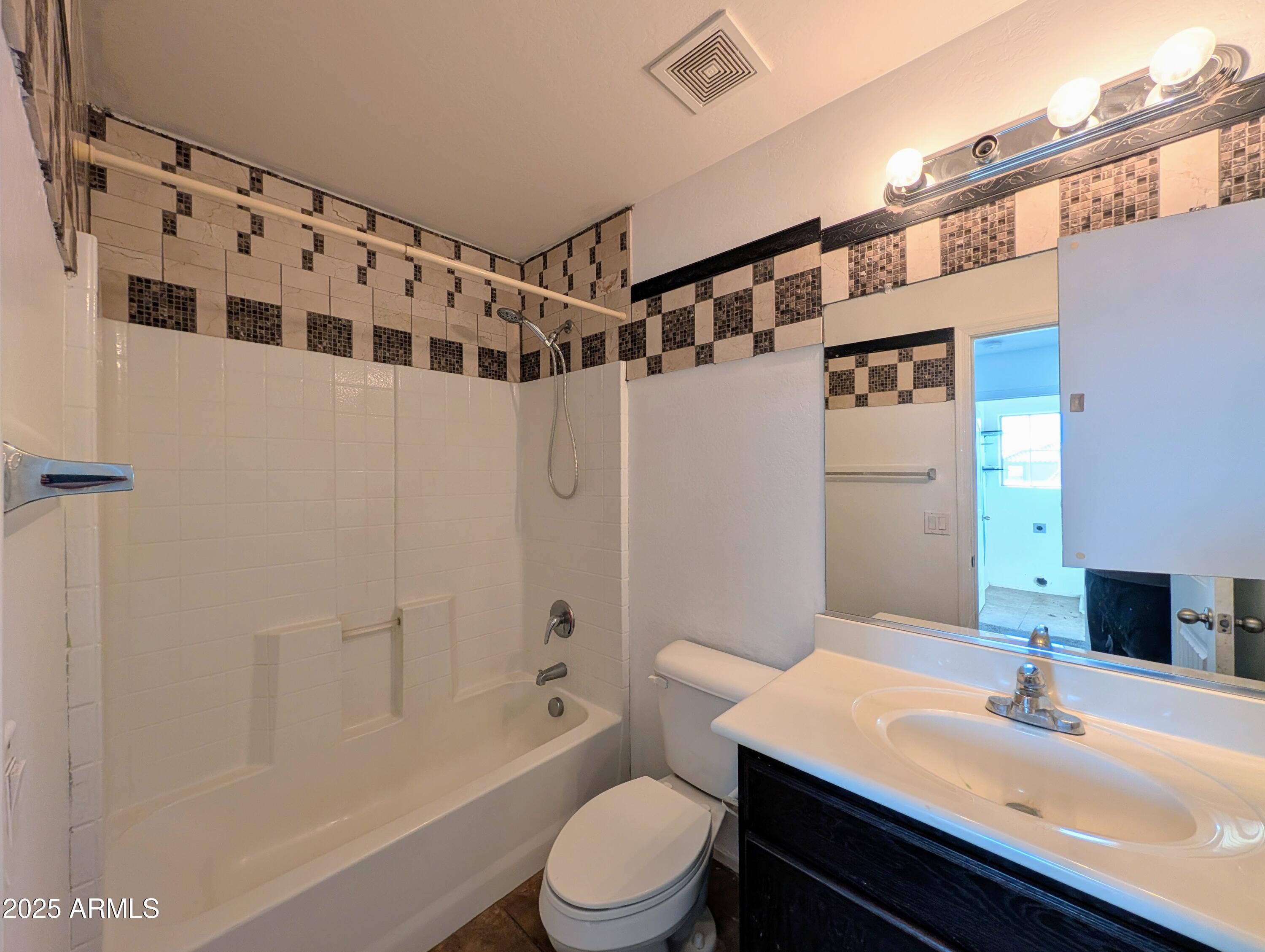 4726 West Fremont Rd. Laveen, AZ 85339 - Photo 36 of 50 a bathroom with a sink a toilet a mirror a vanity and shower