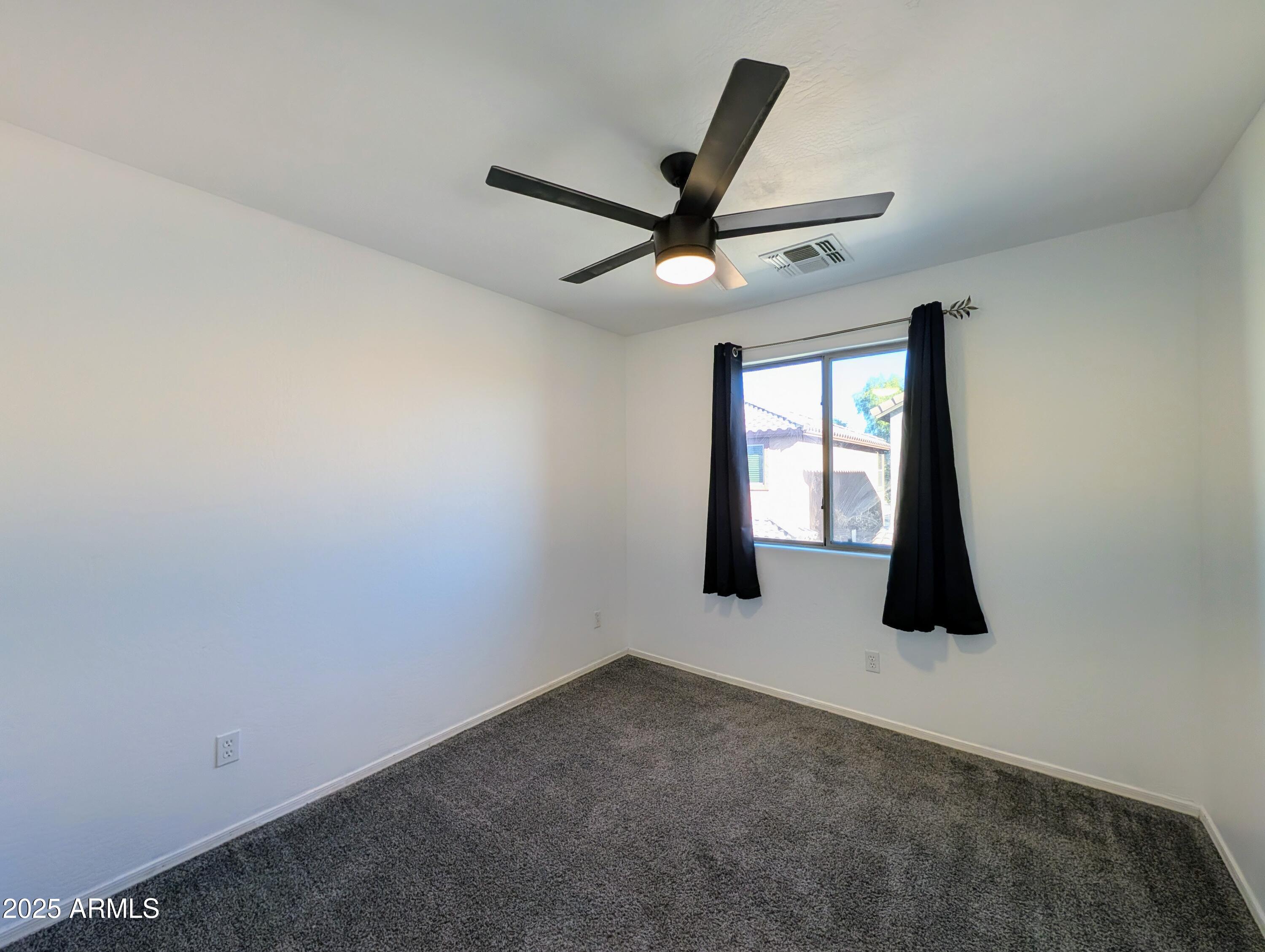4726 West Fremont Rd. Laveen, AZ 85339 - Photo 42 of 50 an empty room with windows and fan