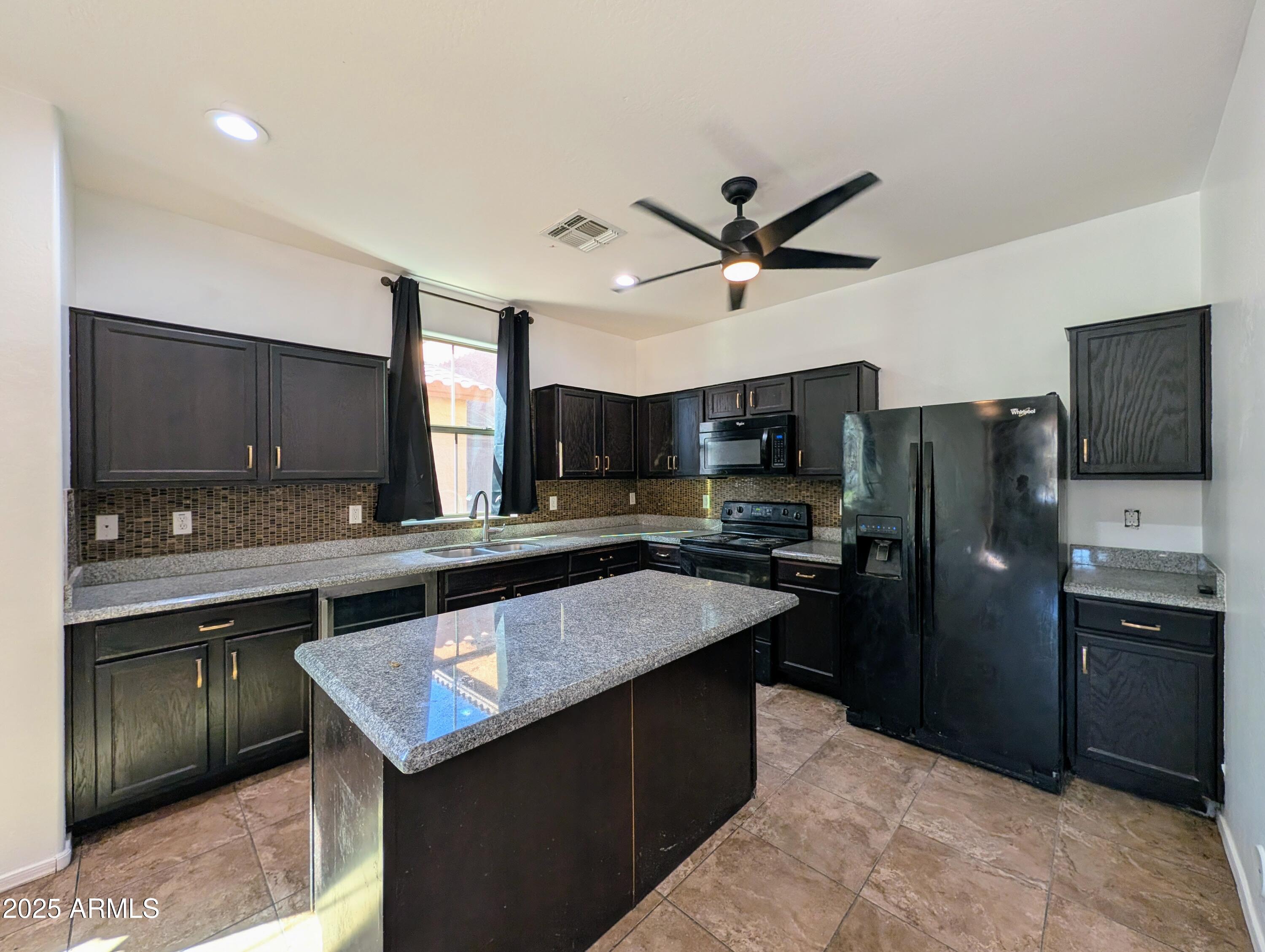 4726 West Fremont Rd. Laveen, AZ 85339 - Photo 10 of 50 a kitchen with stainless steel appliances granite countertop a sink a stove and a refrigerator